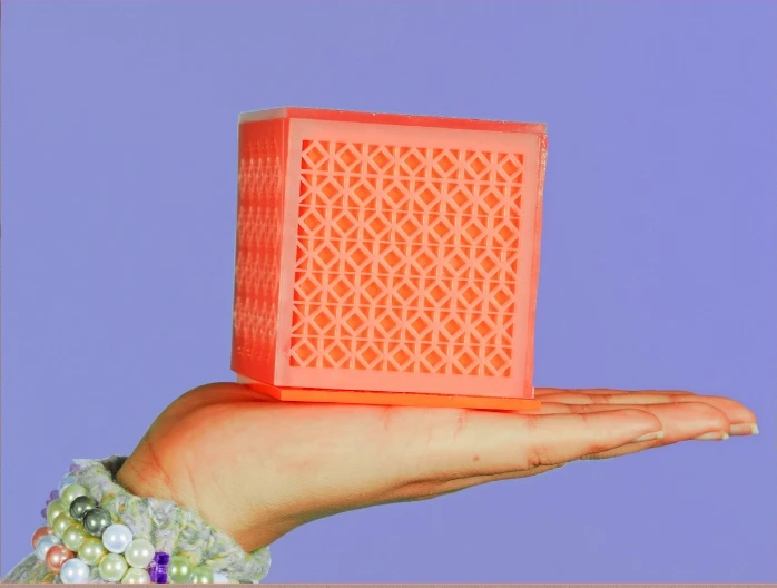 Orange patterned jewellery box held against a lavender backdrop